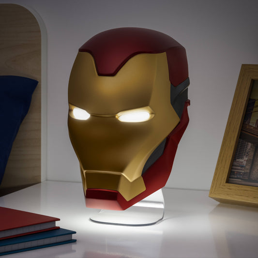 Iron Man helmet lamp on a stand with books and a picture frame in the background
