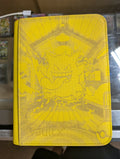 Yellow Pokémon trading card holder with character design on a blurred background